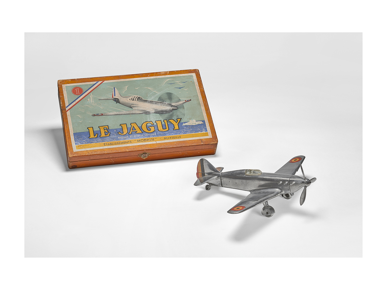 “Le Jaguy” aircraft and its box, Modalu manufacture, 1947. Cast aluminium aircraft, wooden box. Massilia Toy, Marseille © Yves Inchierman